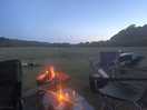 Fire in the old tractor wheel under a beautiful clear night sky.
