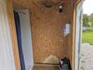 Latched open toilet block door and shower situation.