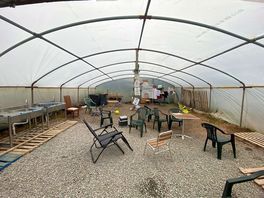 Communal clotheslines, pot wash and water facilities in a large ploy tunnel + communal seating area