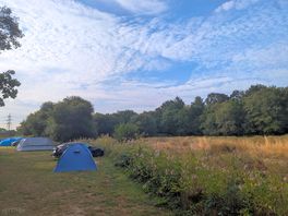 Our tent in grey, river next to and field