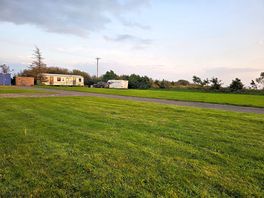Some of the site including mobile home and caravan for hire. the blue building is 2 separate toilets