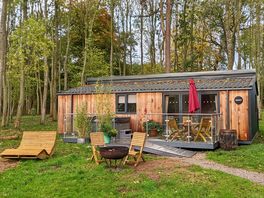 Snowy lodge with outdoor seating and hot tub