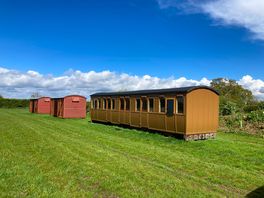 External view of carriage camping pod alongside box wagon camping pods