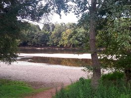 By the river.
