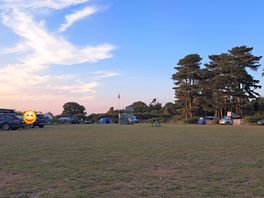 The site with the small play area in the centre and pitches dotted around.