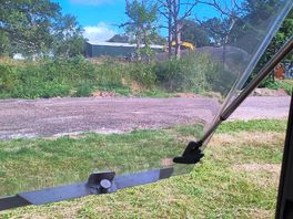 Blick vom campingplatz auf das farmgelände mit bagger...