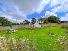 The bell tent pitch with a firepit and picnic bench
