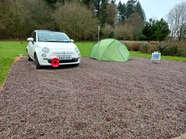 Pitched on gravel with plenty of room for my tent and car together, with an electrical supply nearby