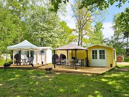 Outside view of the cabin with decking, fire pit, gazebo, seating and kitchen area