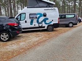 Des vans aménagés sur le parking destinés au voiture