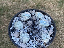 Campfire cooking with baked potatoes.