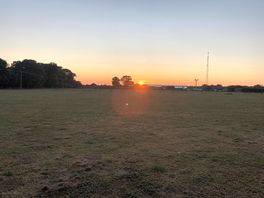 Sunrise over the farm buildings just past the camping field