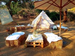 Bell tent pitch with table and bales as chairs
