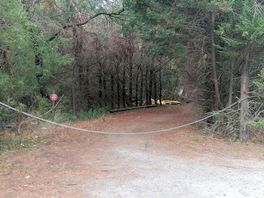 Accès entre le parking et les emplacements tentes. une structure gonflable usagé et poubelle sauvage