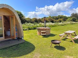 Our camping pod setup with hot tub, bench and fire pit