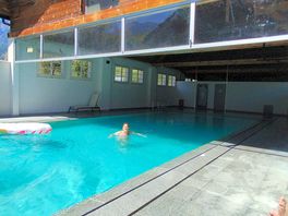 Espacio piscina, con zona climatizada con vistas a la montaña.