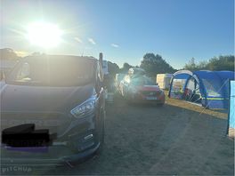 Caravan behind the van right beside the red car opening onto it