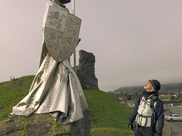 Castle ruins in town with statue