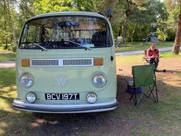 Our old vw camper on the main field with a chap sat on a chair beside it