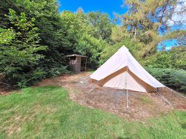 This pitch shows it with a bell tent in situ. Covered picnic area and firepit in background