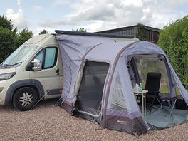 Campervan on fully serviced hardstanding pitch with awning.