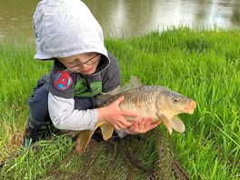 Young boy with a carp from the fishing lake