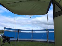 Makeshift awning with tent door and leftover poles from a broken windbreaker