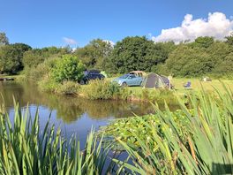 Camping pitches next to the small lake in the main camping field. There’s a second field no lake