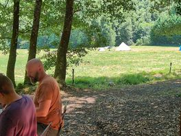 Uitzicht vanuit het huisje met daarachter een beekje waar in gespeeld en gezwommen kan worden