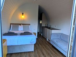 View inside with sitting area, space saving dining table, tv and kitchen