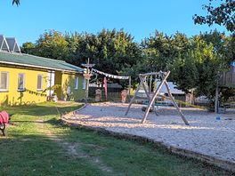 Spielplatz, im hintergrund das gebäude mit wcs, duschen usw.