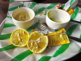 Lemon pieces next to fish and chips