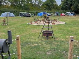 View from covered communal area that has seats / table bbq hah faves where the tents are situated