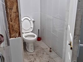 Dirty toilet, missing tiles