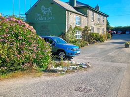 The cottage to the side of the pub nearest car