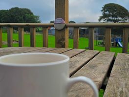 Cup of coffee on decking.