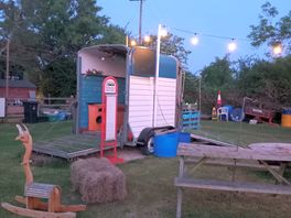 Horsebox and seating area at night.