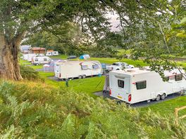 Main site with toilet and shower block in background.