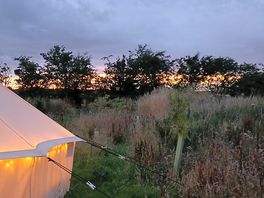 Cosy bell tent with fairy lights, and a beautiful sunset