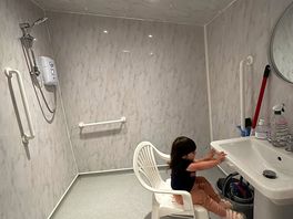 Shower room - our daughter using the sink with plastic chair provided.