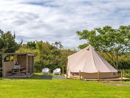 Bell tent with private kitchen shelter in the wild field