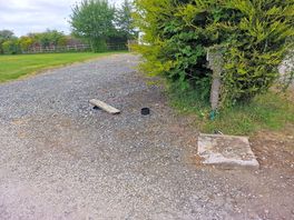 Open manhole covered with a plank of wood.