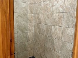 Shower , has stool to sit on.