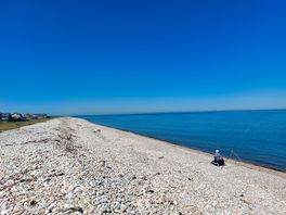 The beach 1 min walk from site to the west