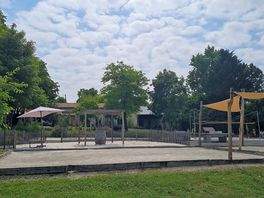View from the pool of the petanque courts with the bar and reception building in thr background