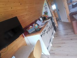 Dining table and kitchen area with the bathroom at the back