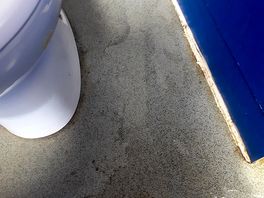 Water spilling out over shower tray and into toilet cubicles