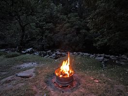The firepit lit next to the river