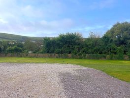 Level gravel pitches for motor homes views of the hills but not the sea.