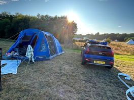 Tent setup next to car behind the bell tents